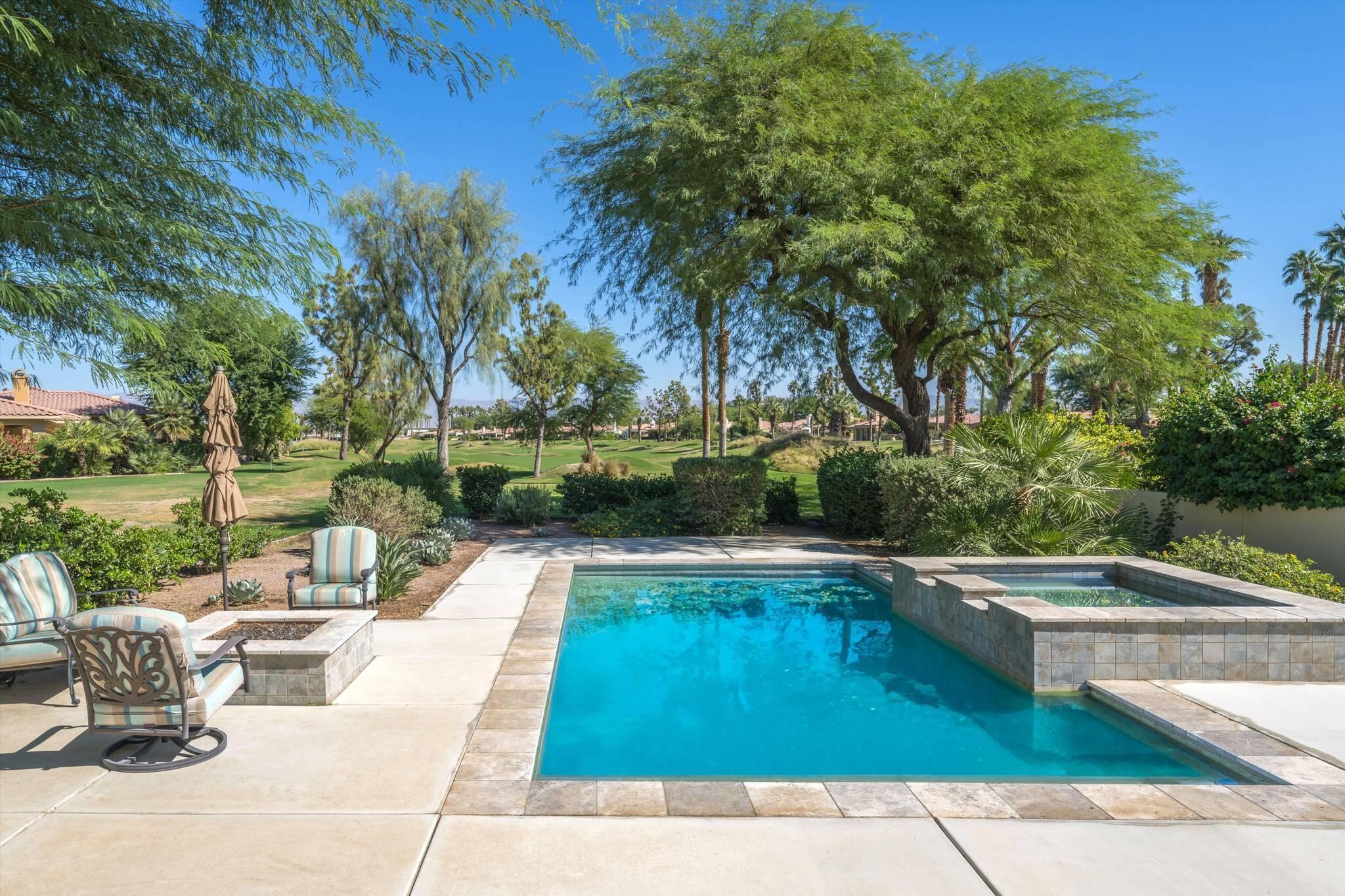 a view of swimming pool with sitting area and garden