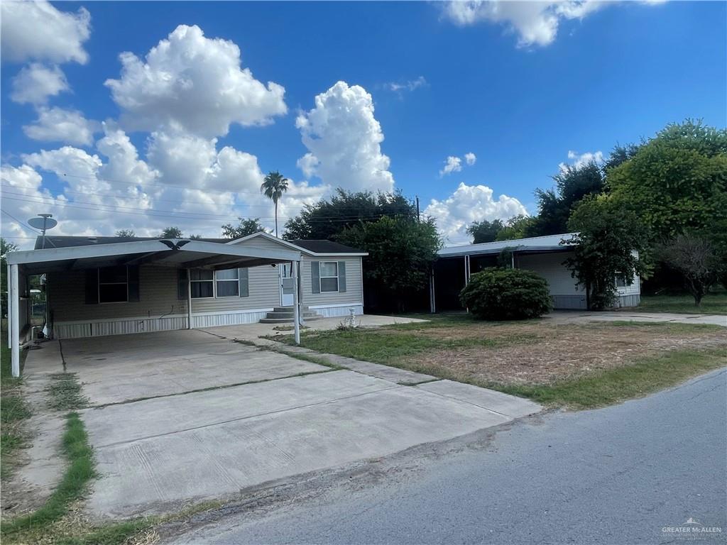 View of front of both  mobile homes featuring a carport each