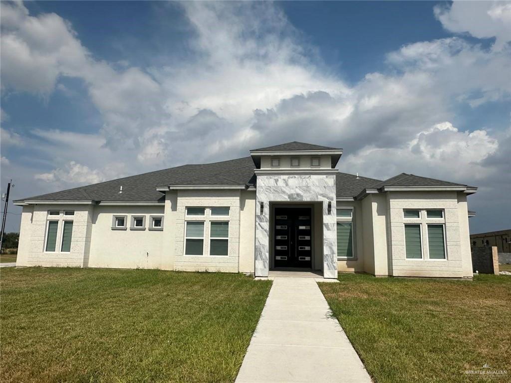 a view of a house with many windows and a yard