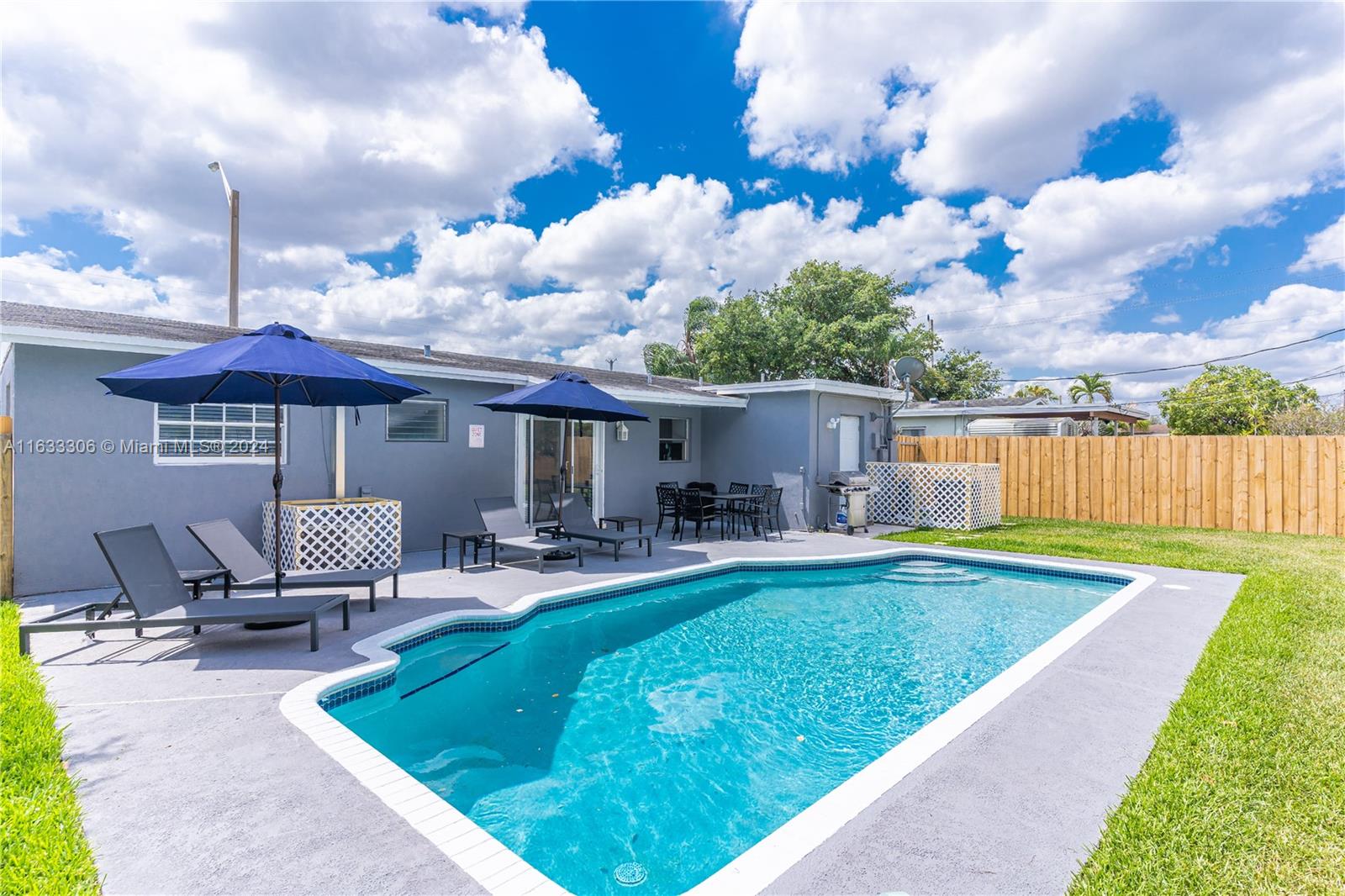 a view of a house with backyard and sitting area