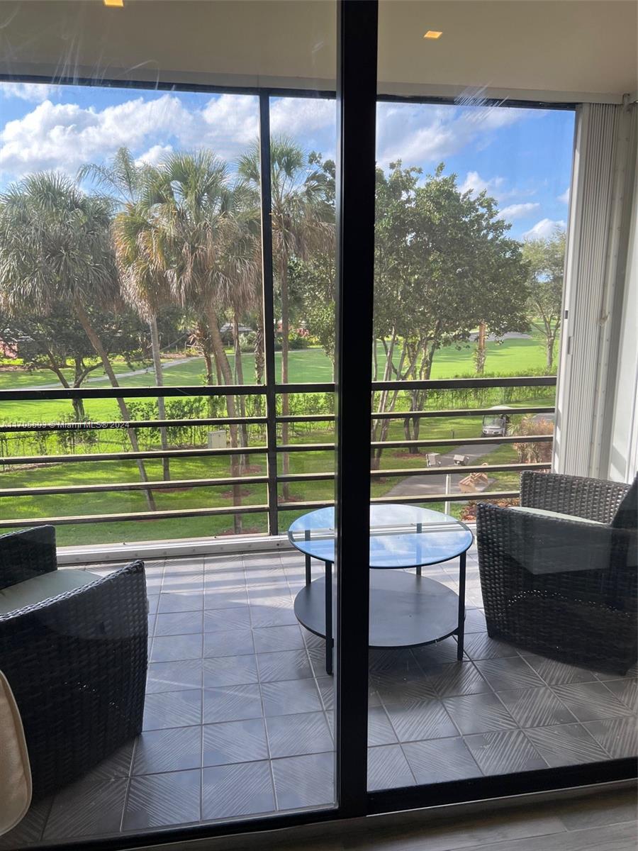 a view of a porch with a table chairs and a floor to ceiling window