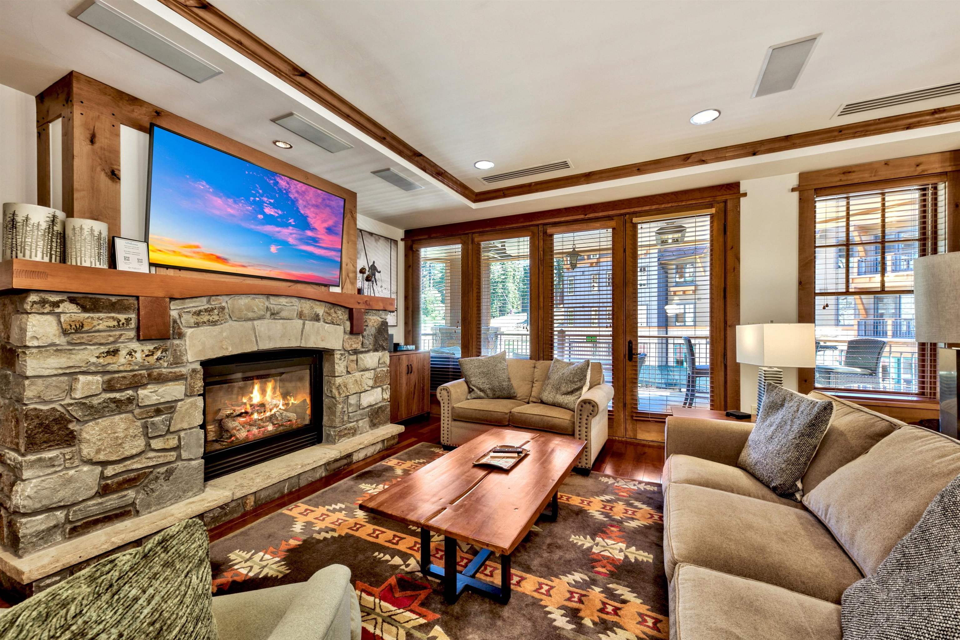 a living room with furniture a fireplace and a floor to ceiling window