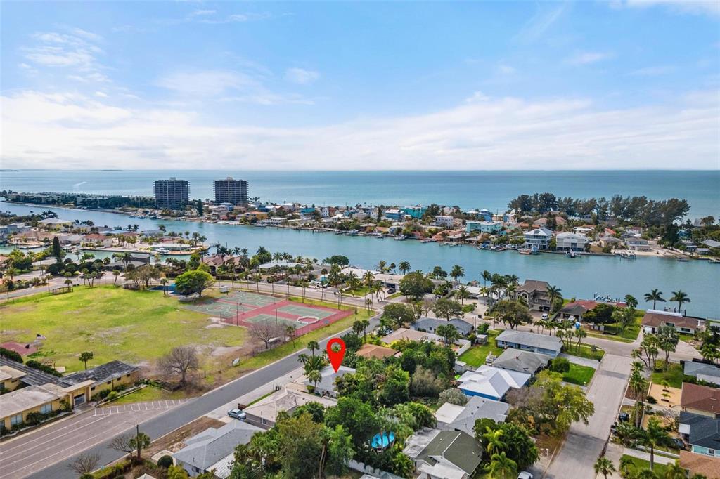 an aerial view of a city with lots of residential buildings ocean and mountain view in back