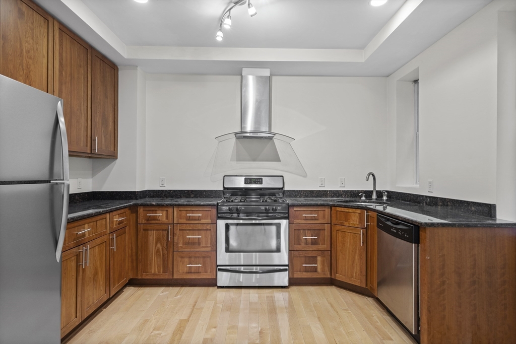 a kitchen with stainless steel appliances granite countertop a stove and a sink