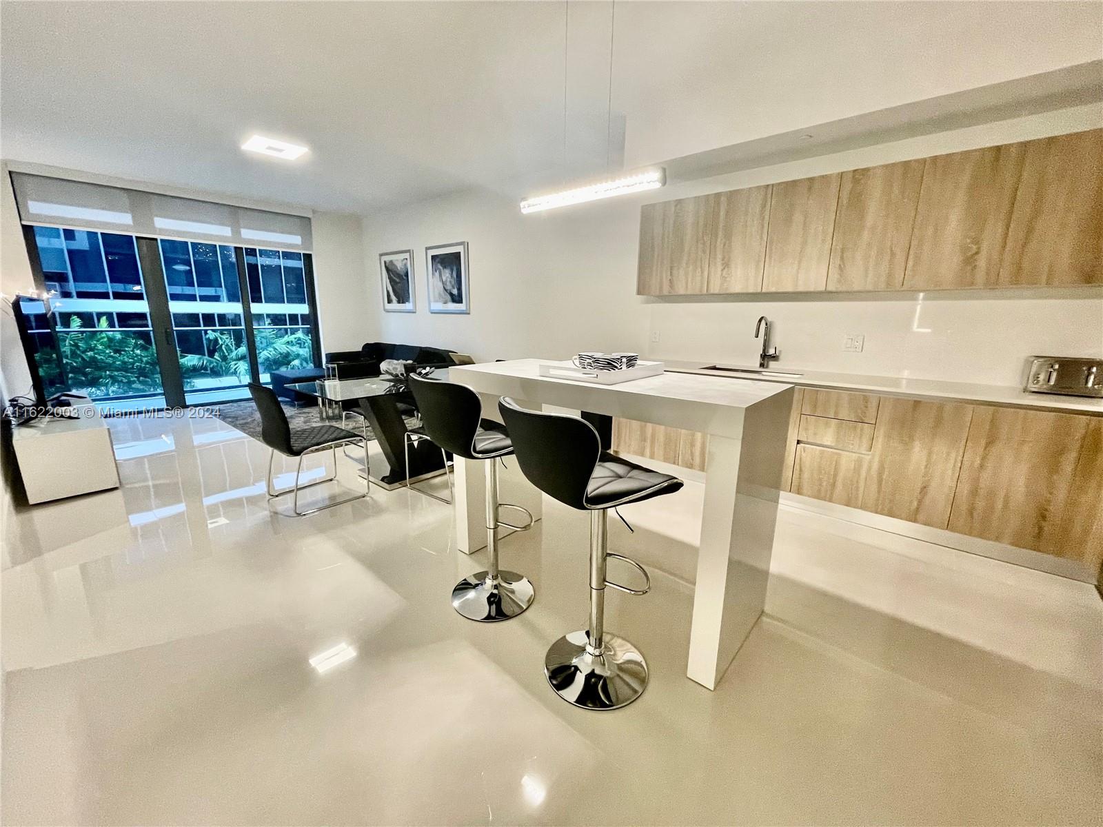 a kitchen with a sink cabinets and living room view