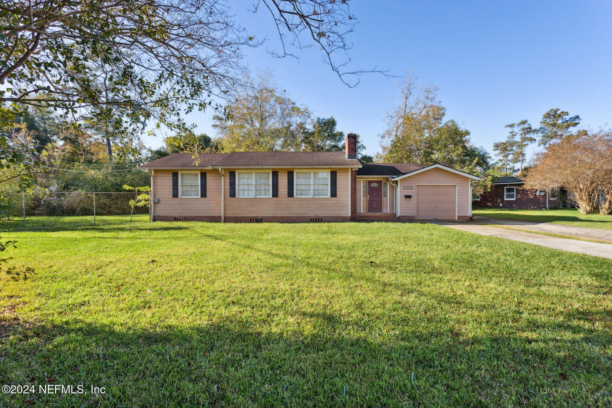 a front view of house with yard and trees in the background