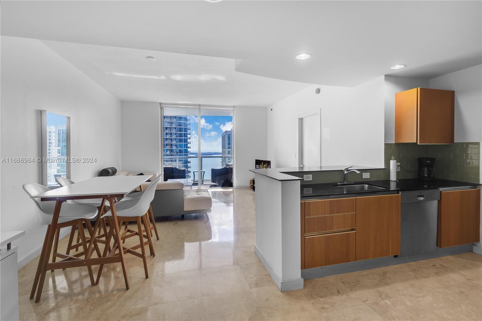 a kitchen with stainless steel appliances kitchen island granite countertop a sink and a refrigerator