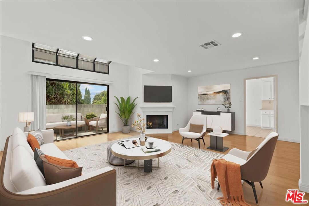 a living room with fireplace furniture and a large window