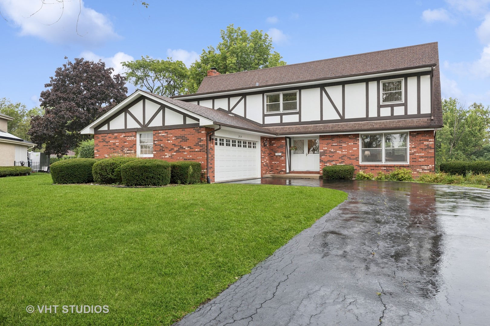 a front view of a house with a yard and potted plants