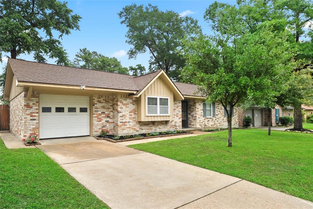 a front view of a house with a yard and trees