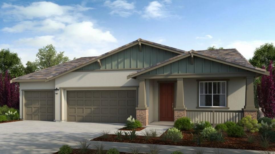 a front view of a house with garage and plants