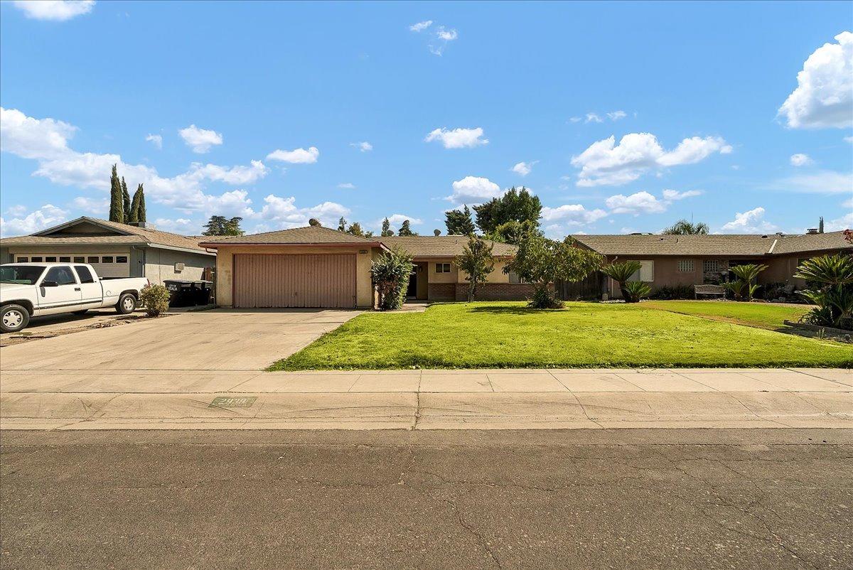 a front view of a house with a yard and a garage