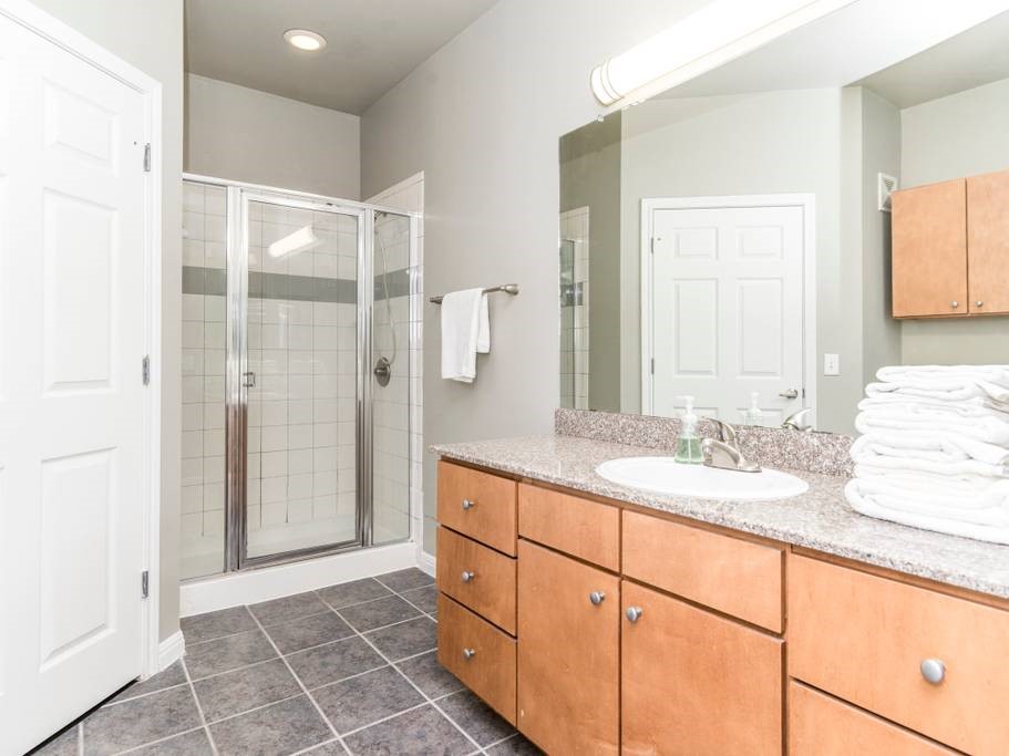 a spacious bathroom with a shower sink and mirror