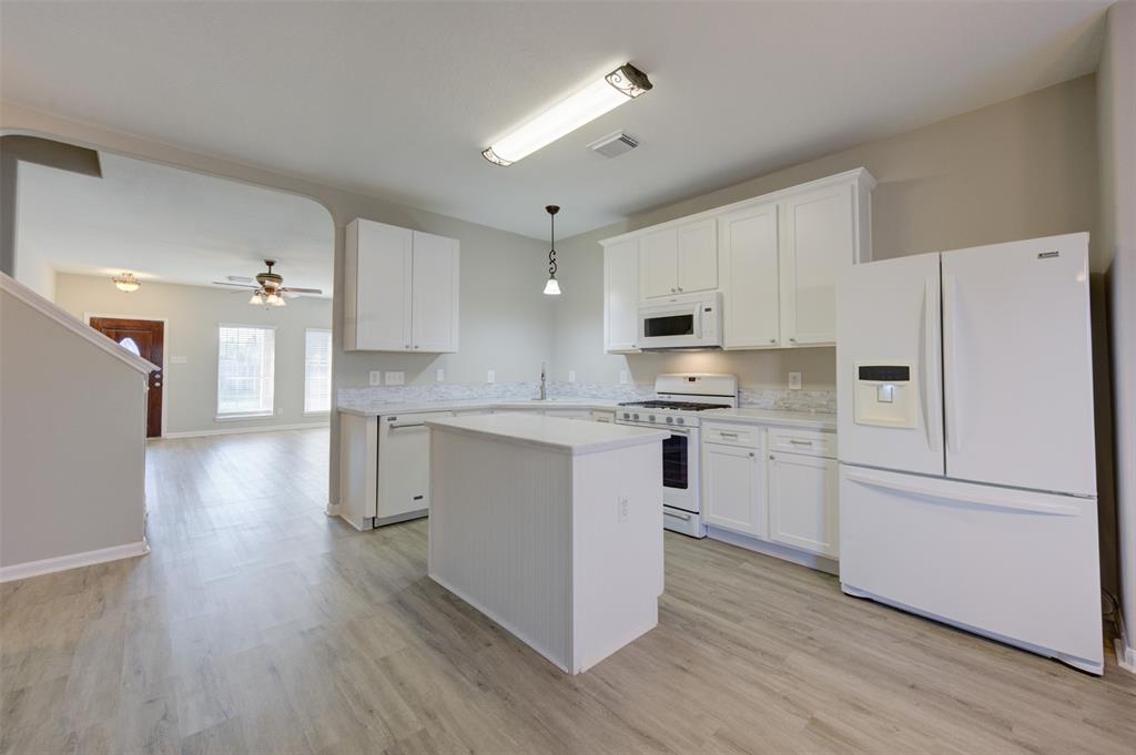 a kitchen with white cabinets and white appliances