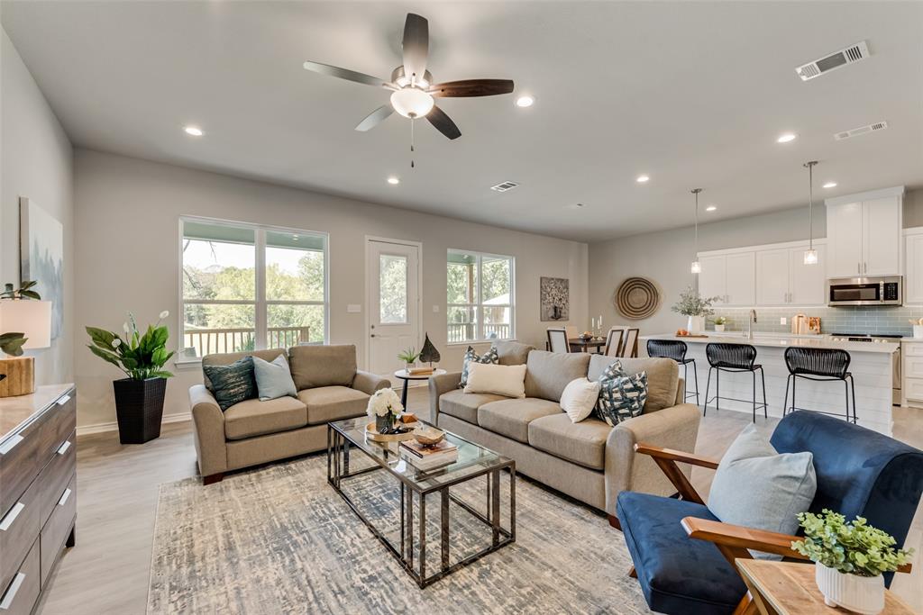 a living room with furniture kitchen and a large window