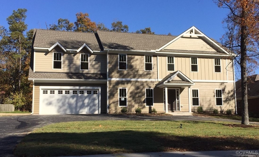 View of front facade with a garage and a front law