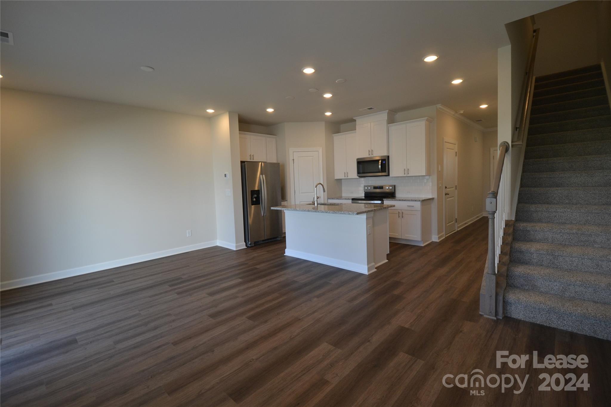 a kitchen with a refrigerator and a stove top oven