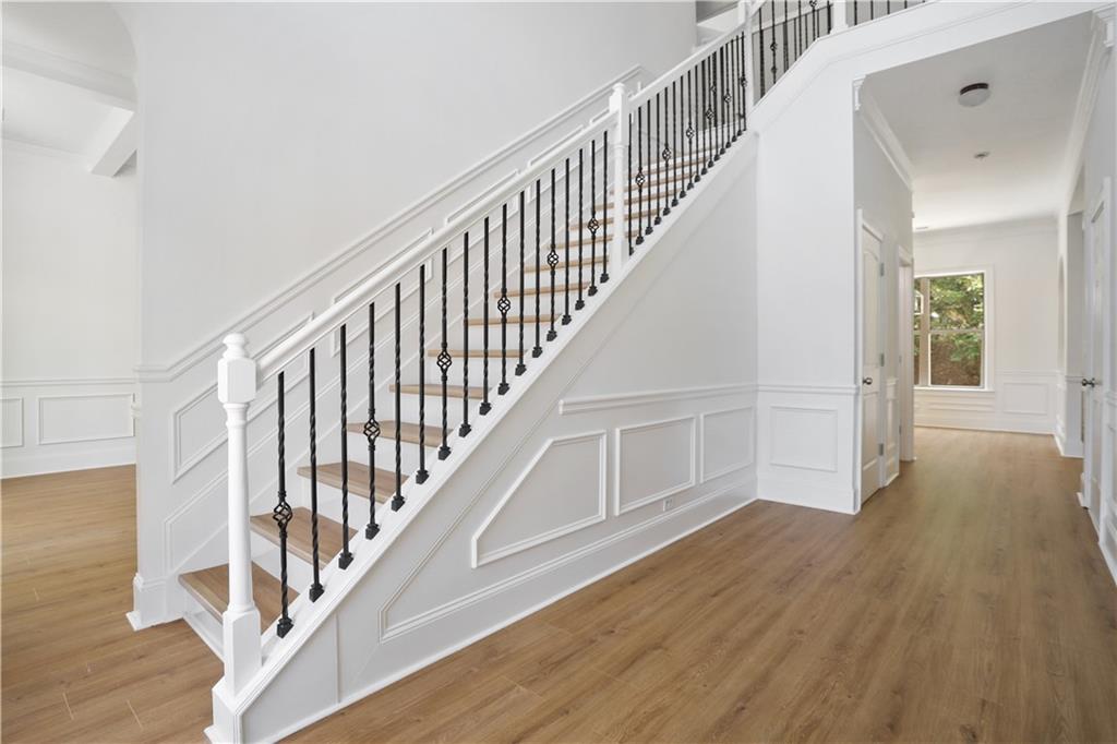 a view of staircase with wooden floor and white walls