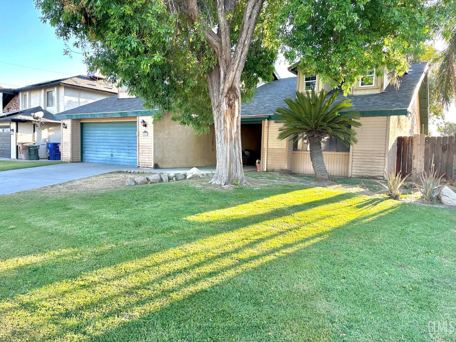 a view of a house with a yard and palm trees