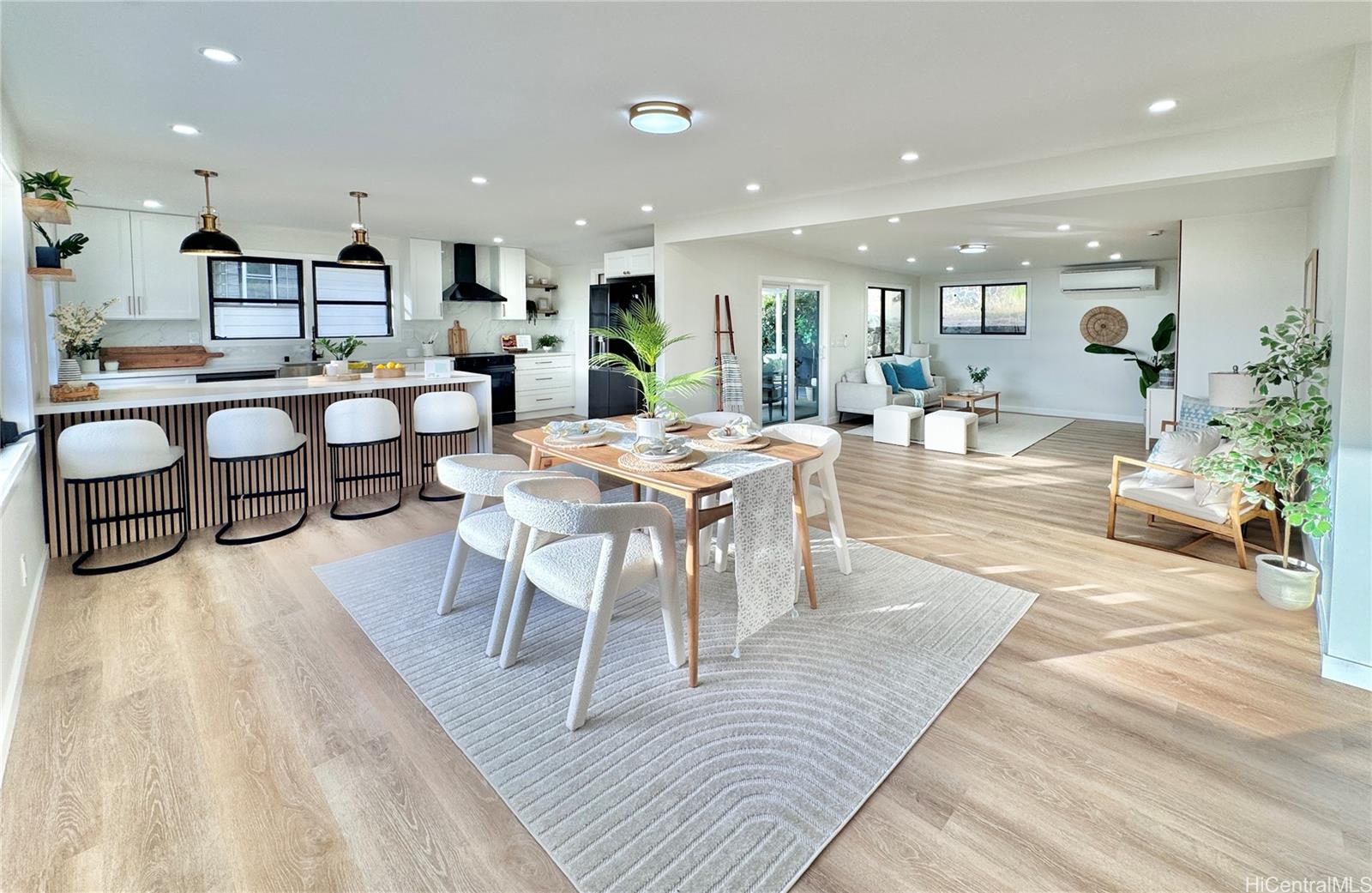 a living room with furniture a wooden floor and a potted plant