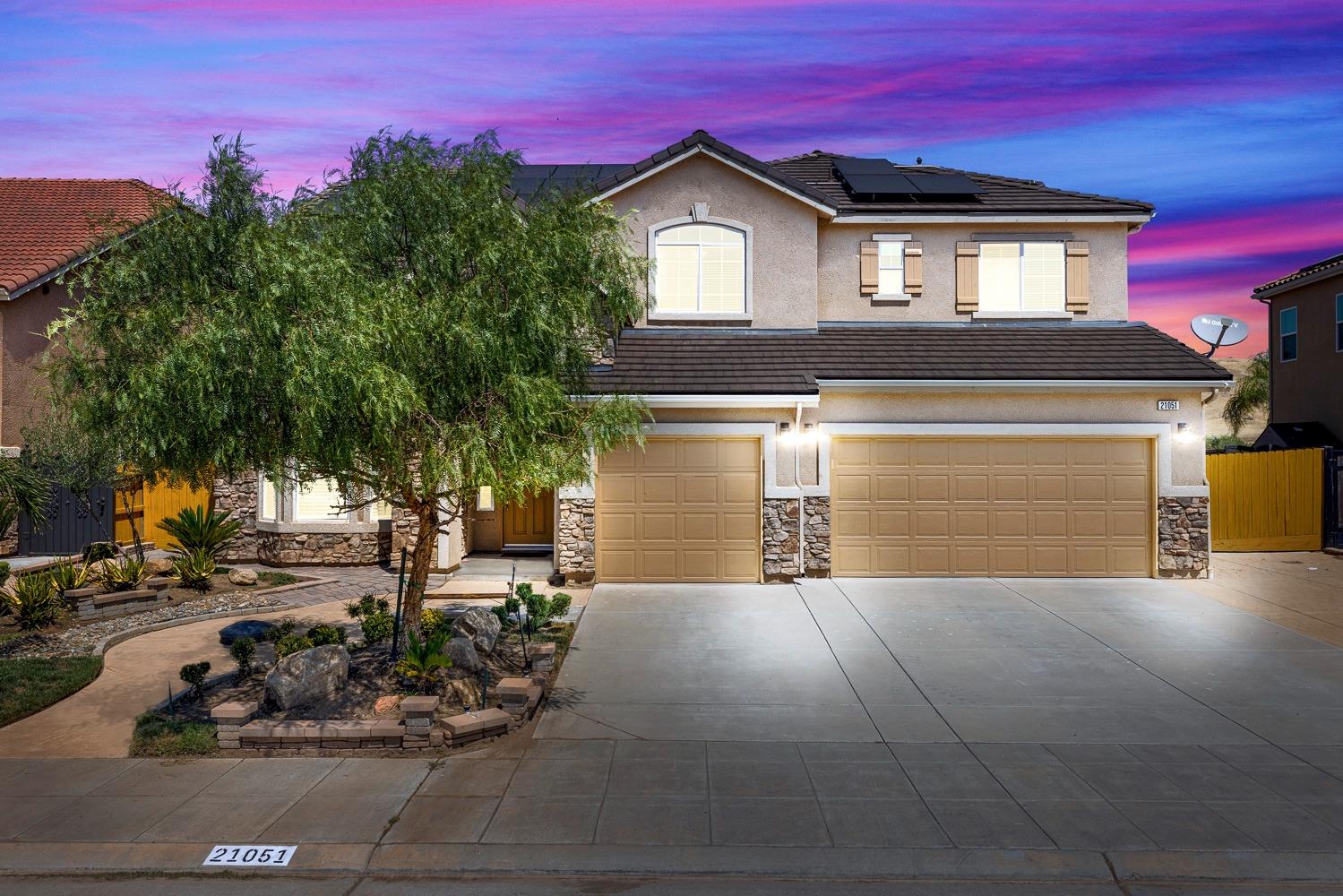 a front view of a house with a yard and garage