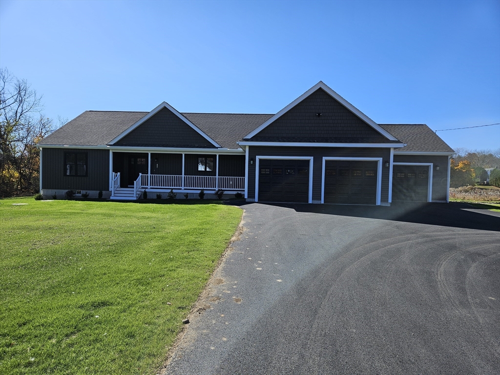 a front view of a house with a yard and trees