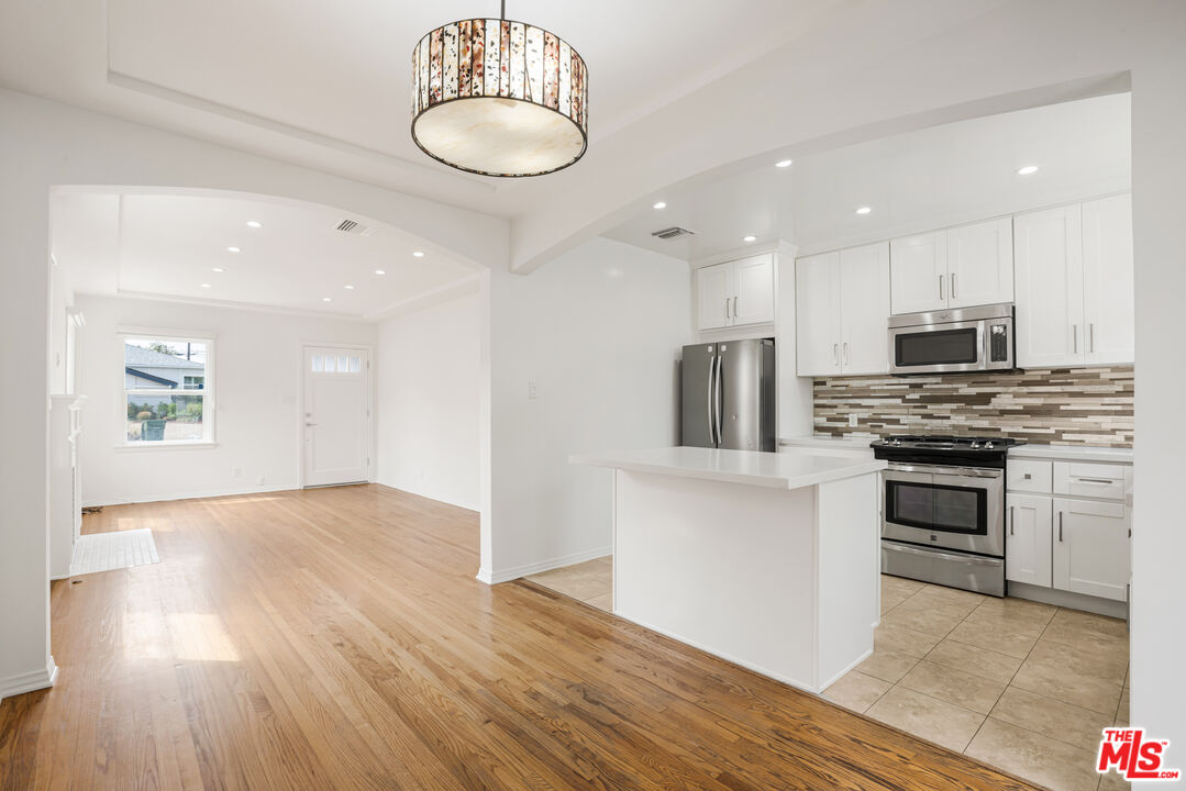 a kitchen with stainless steel appliances a stove top oven and refrigerator