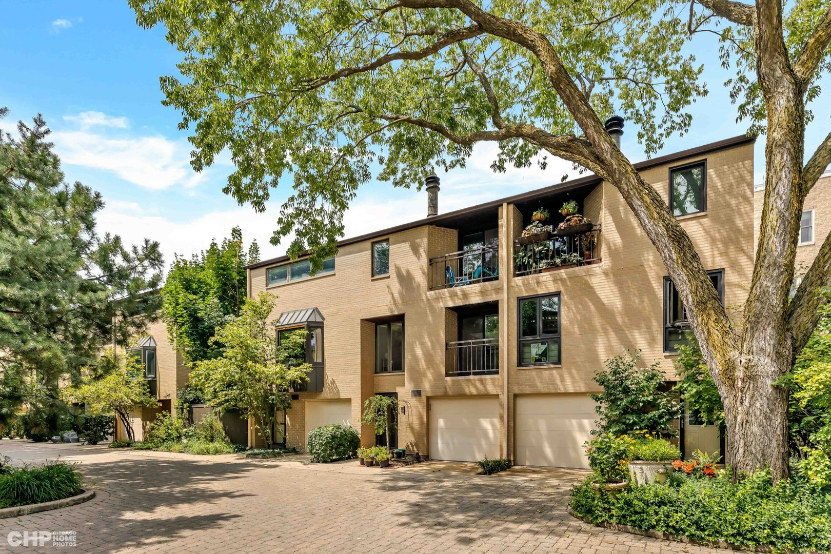 a front view of a house with a tree