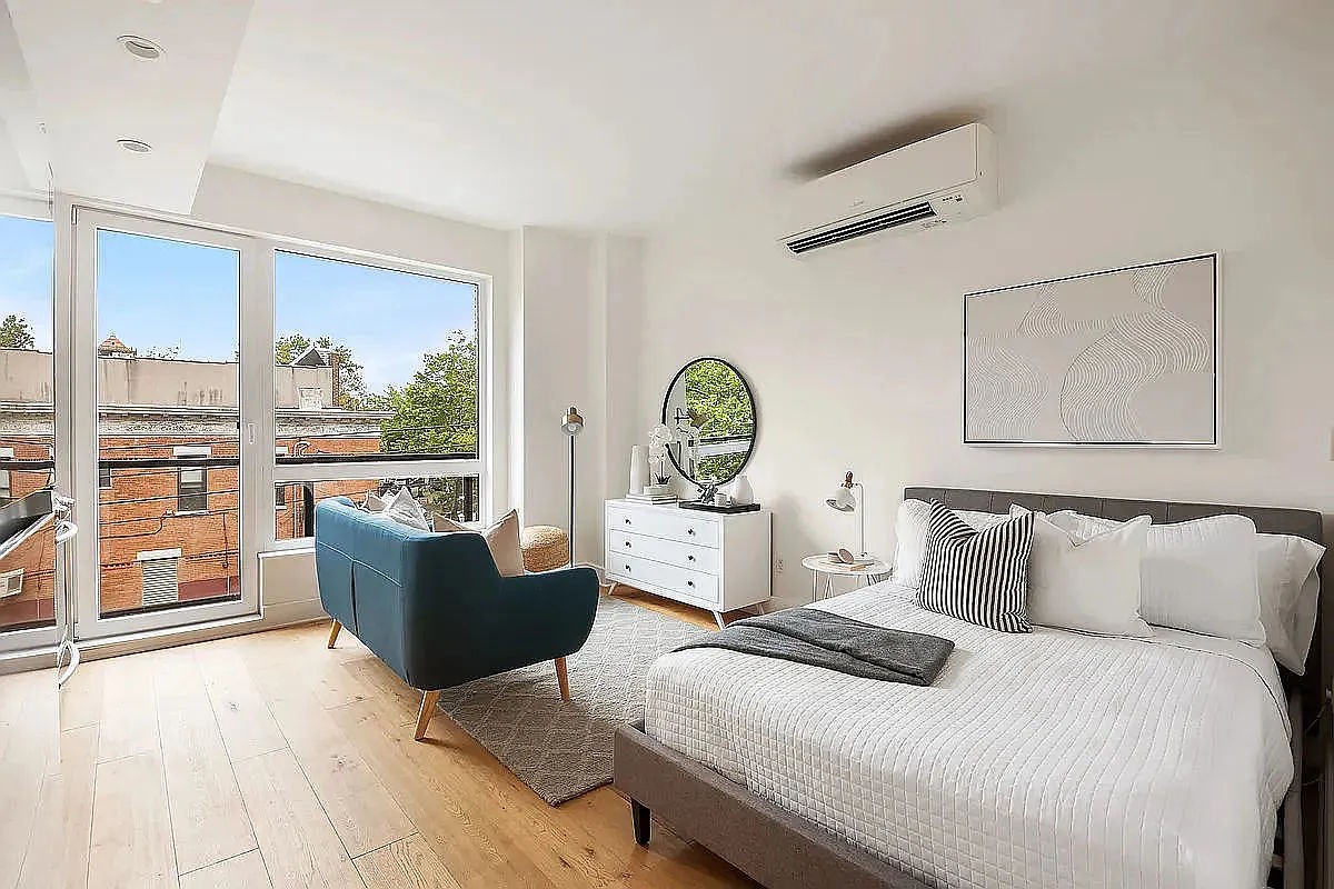 a bedroom with a bed and large windows