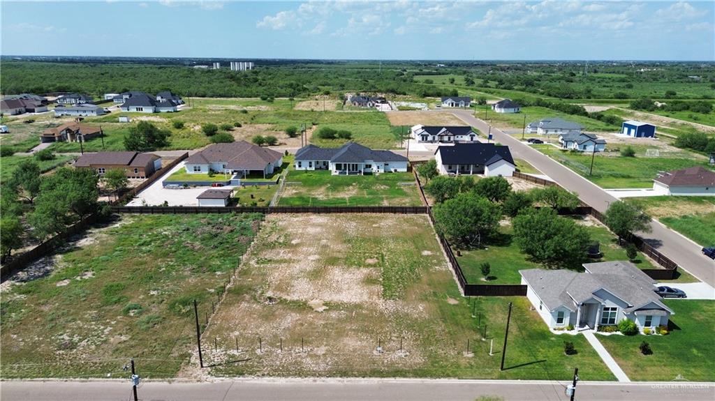 an aerial view of residential houses with outdoor space and trees