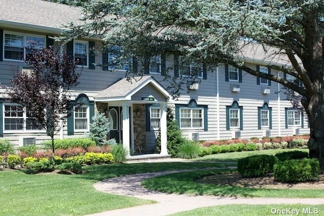 a front view of a house with a yard and potted plants