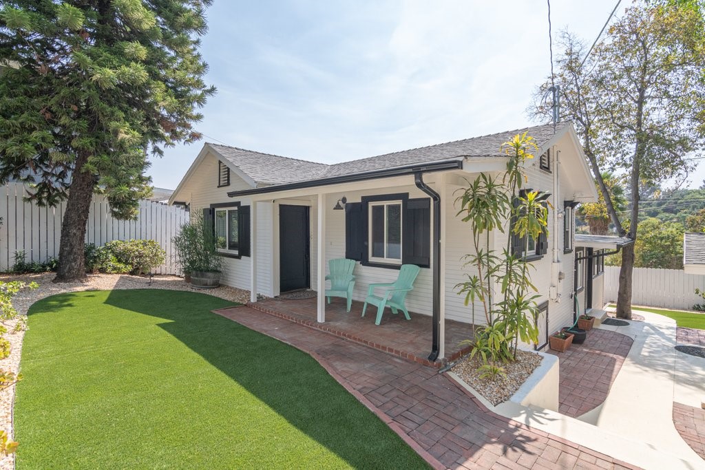 a view of a house with backyard sitting area and garden