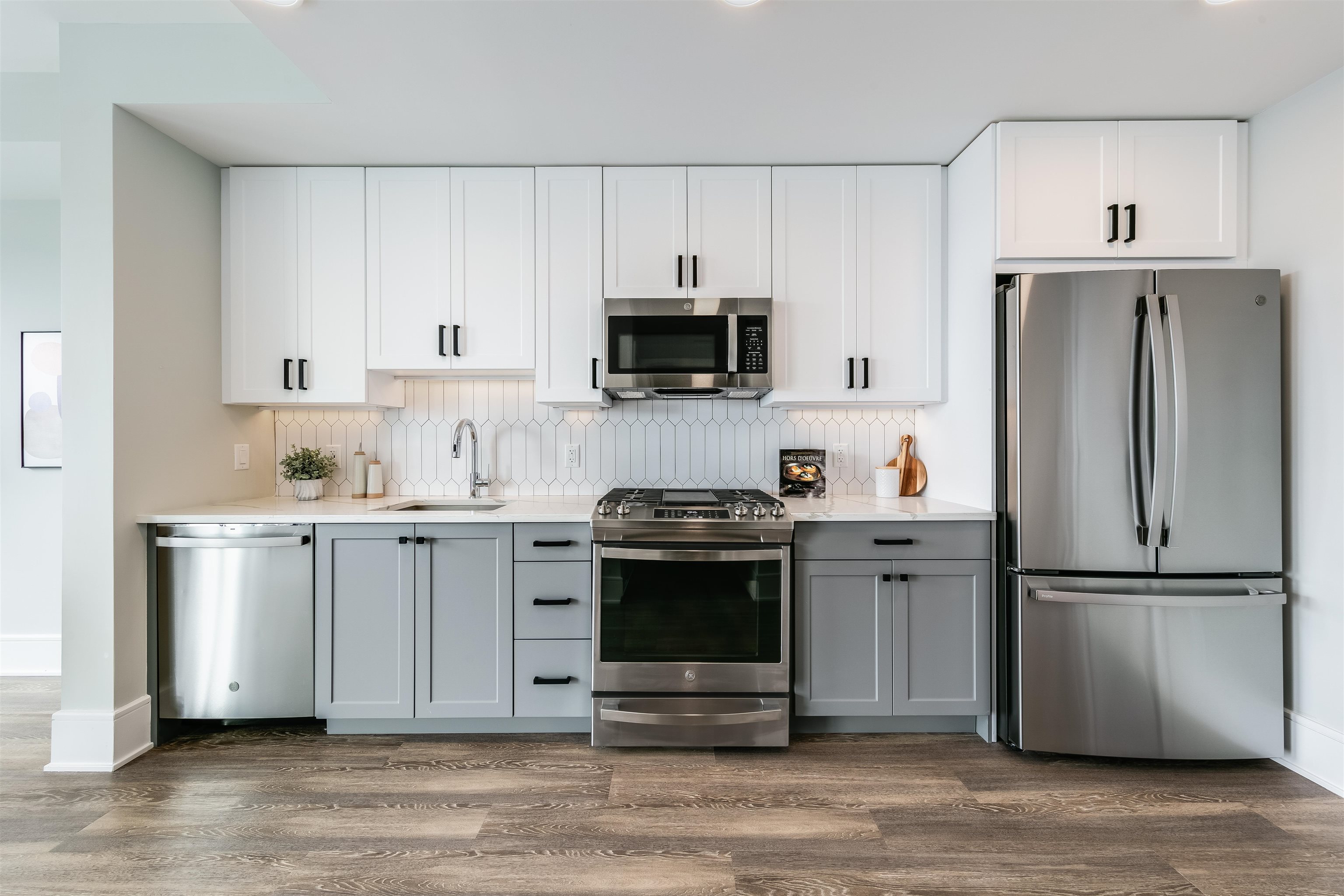 a kitchen with a refrigerator stove and white cabinets