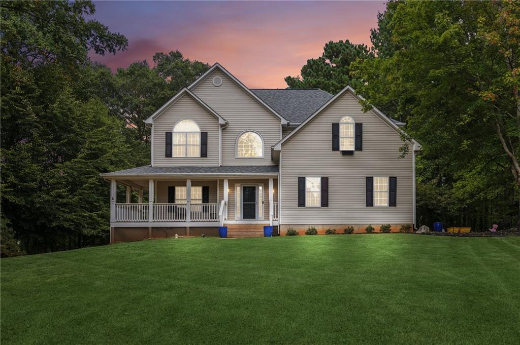 a front view of a house with a yard and trees