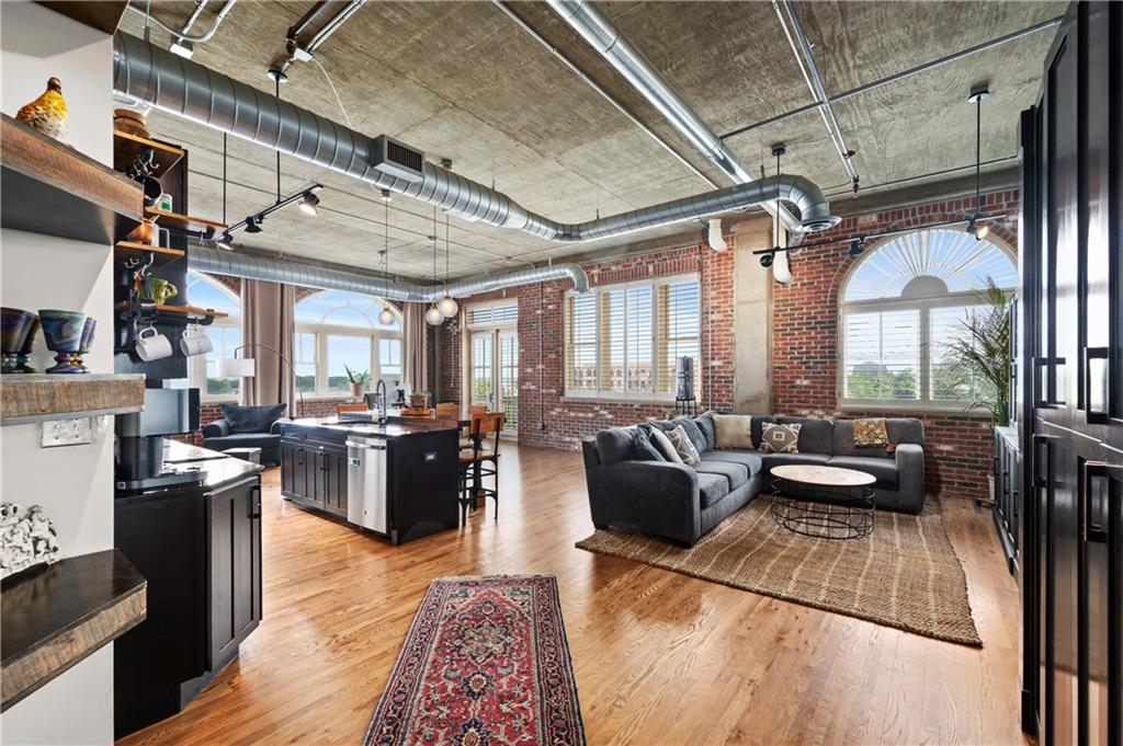 a living room with furniture large window and wooden floor