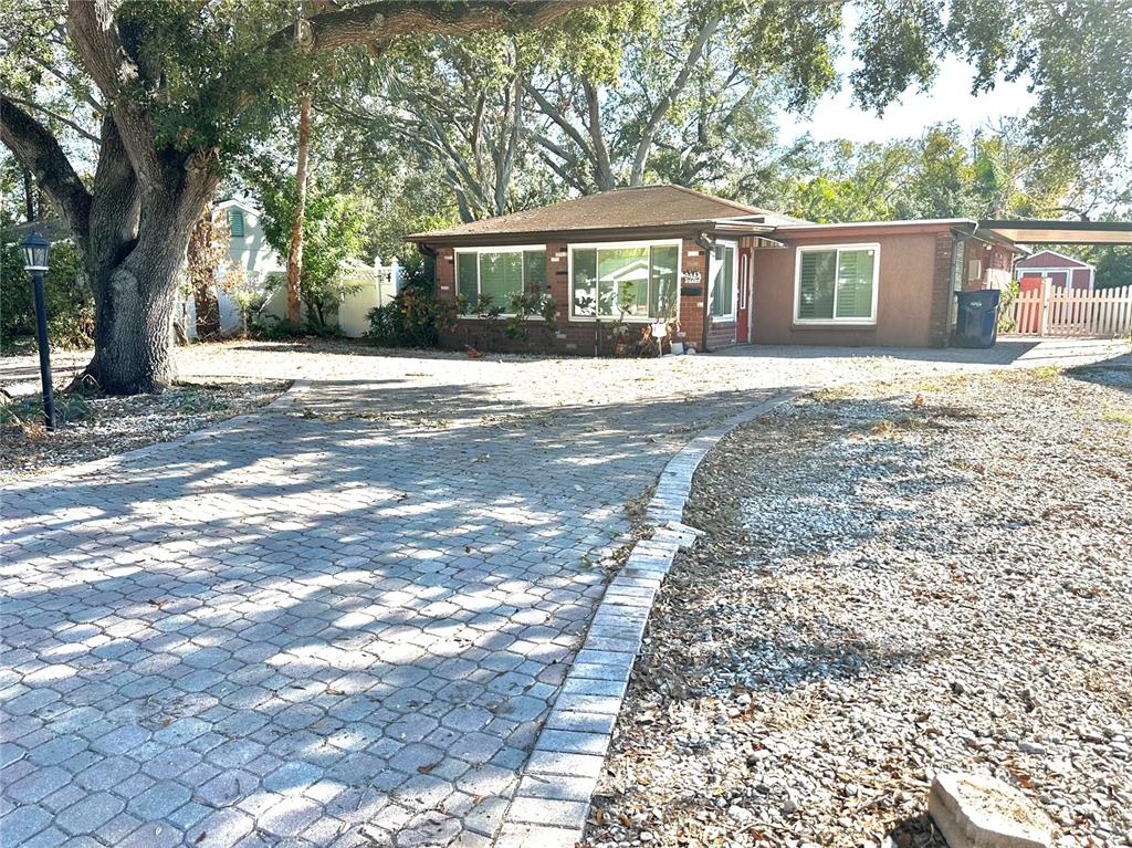 a front view of a house with a yard and trees