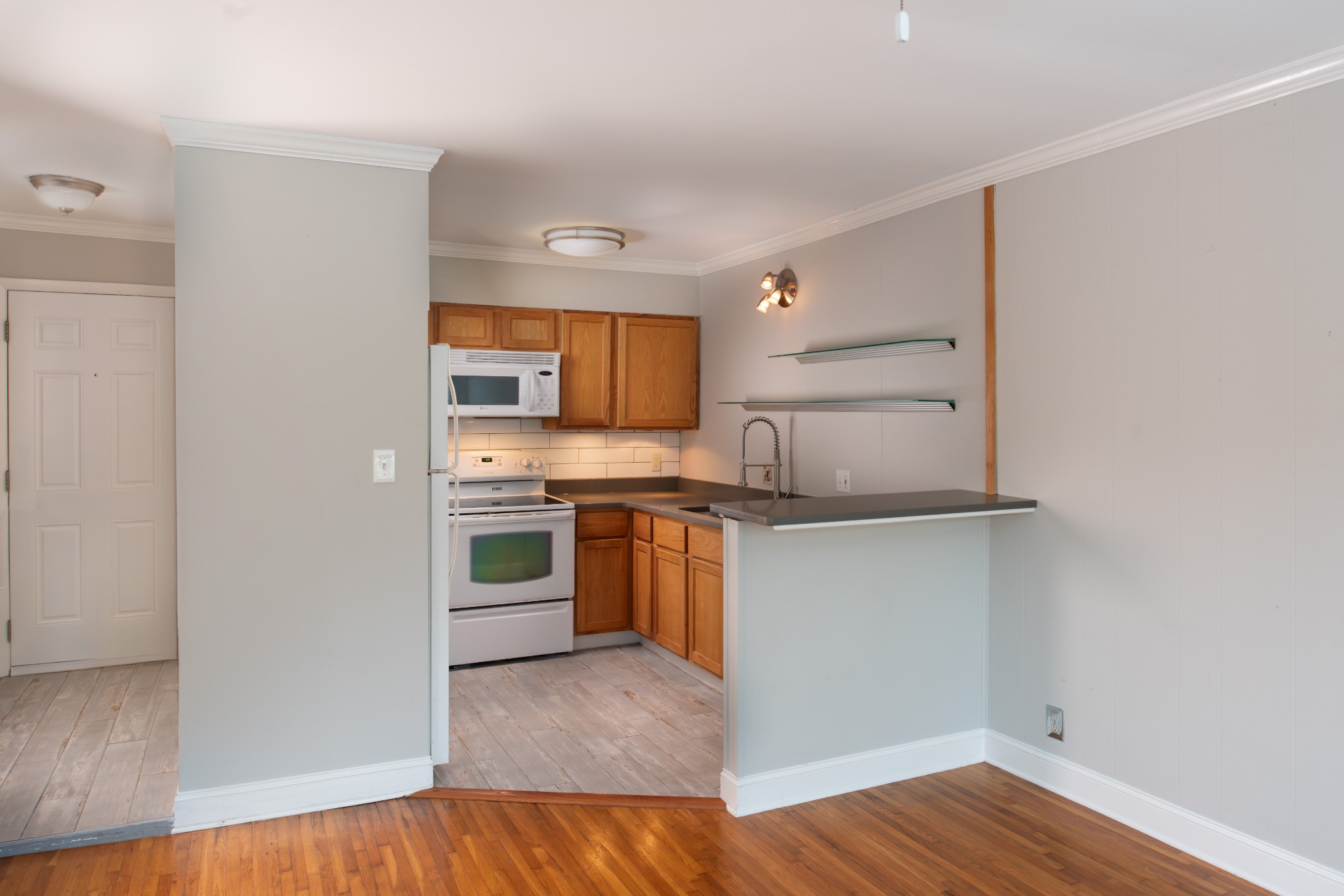 a kitchen with a refrigerator and a stove top oven