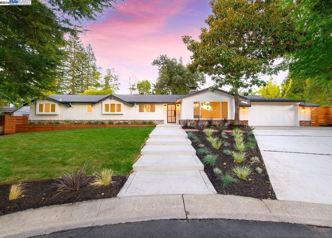 a front view of a house with a yard and potted plants