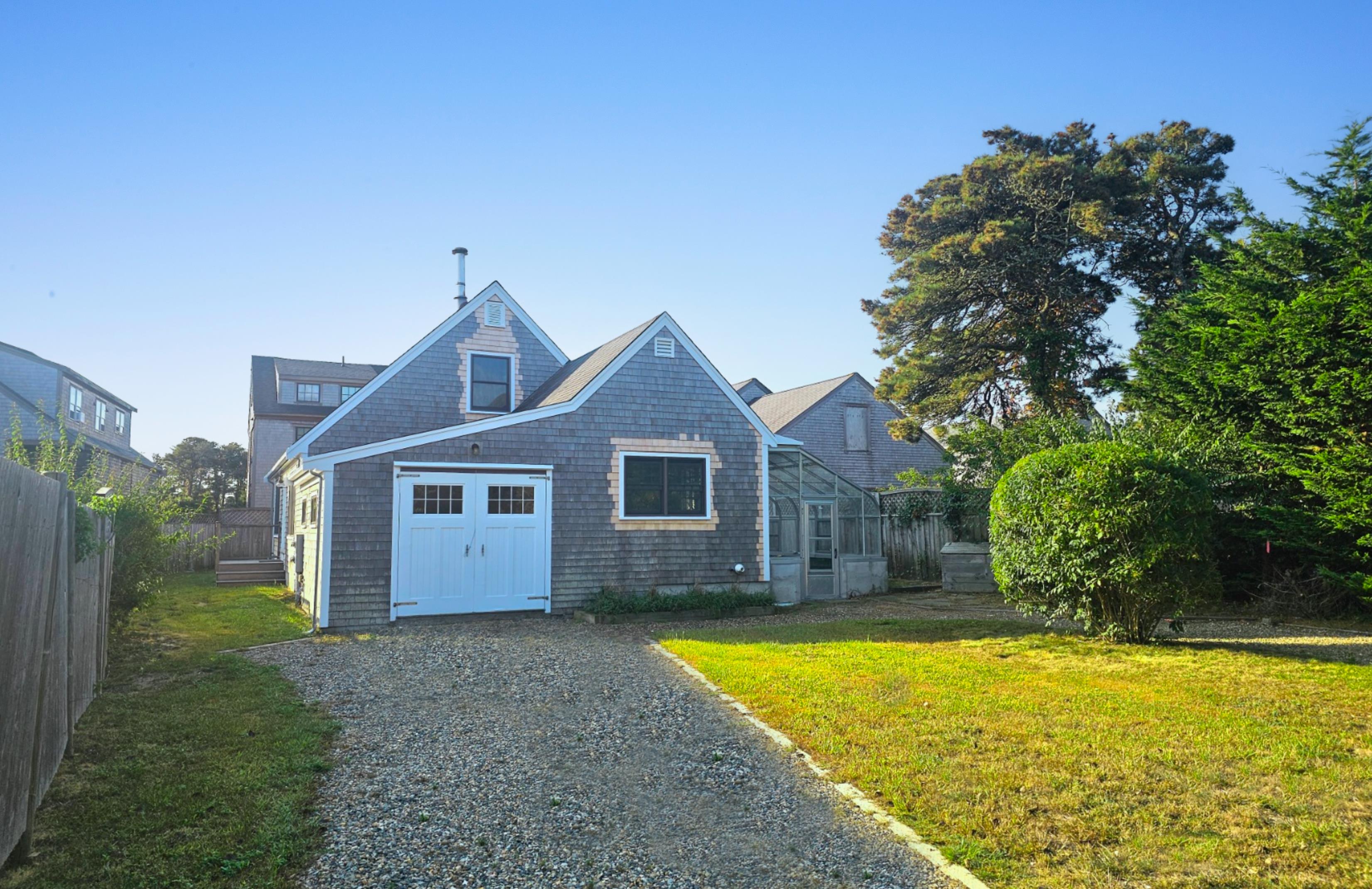 a view of a house with a yard and large tree