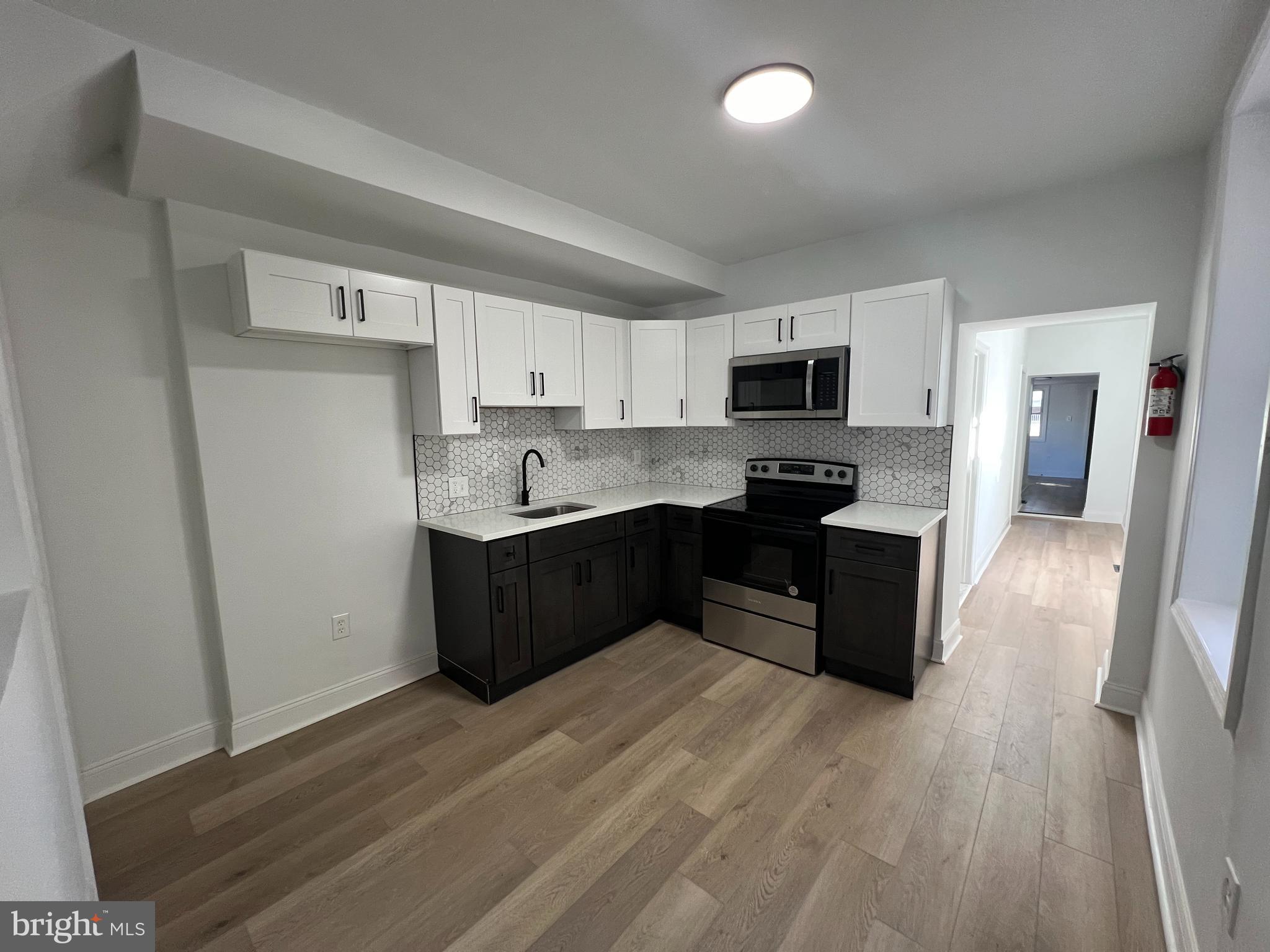 a kitchen with granite countertop a refrigerator and a stove top oven