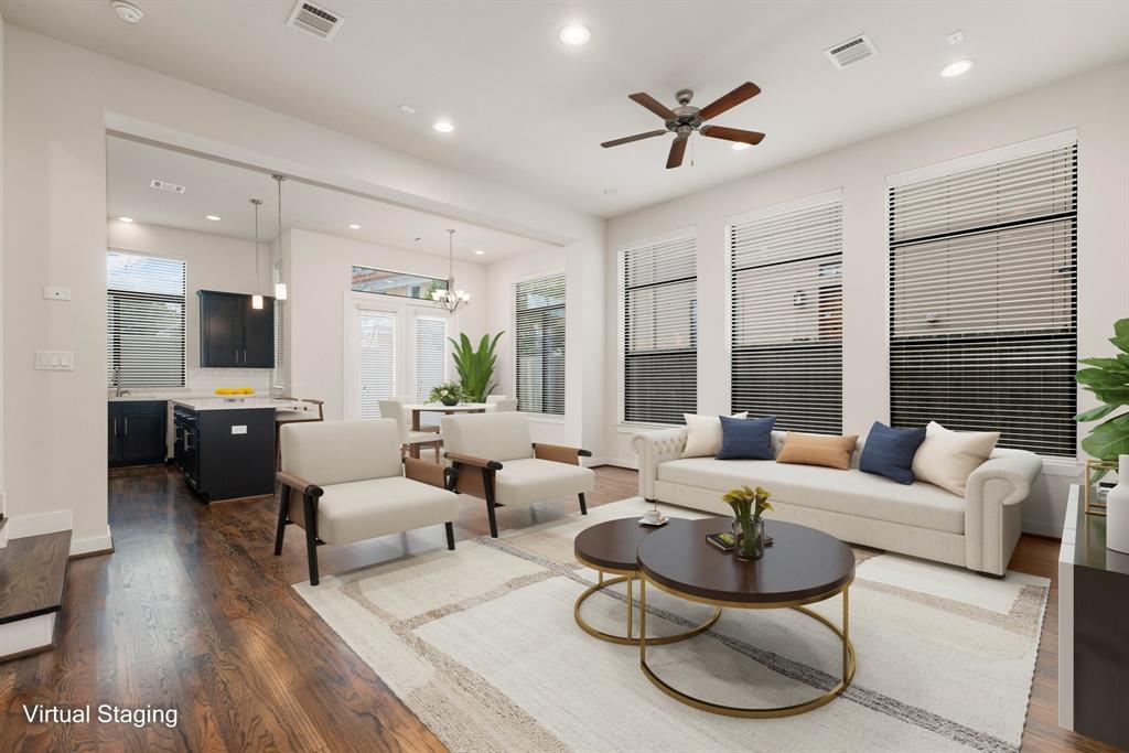 a living room with furniture ceiling fan and a large window