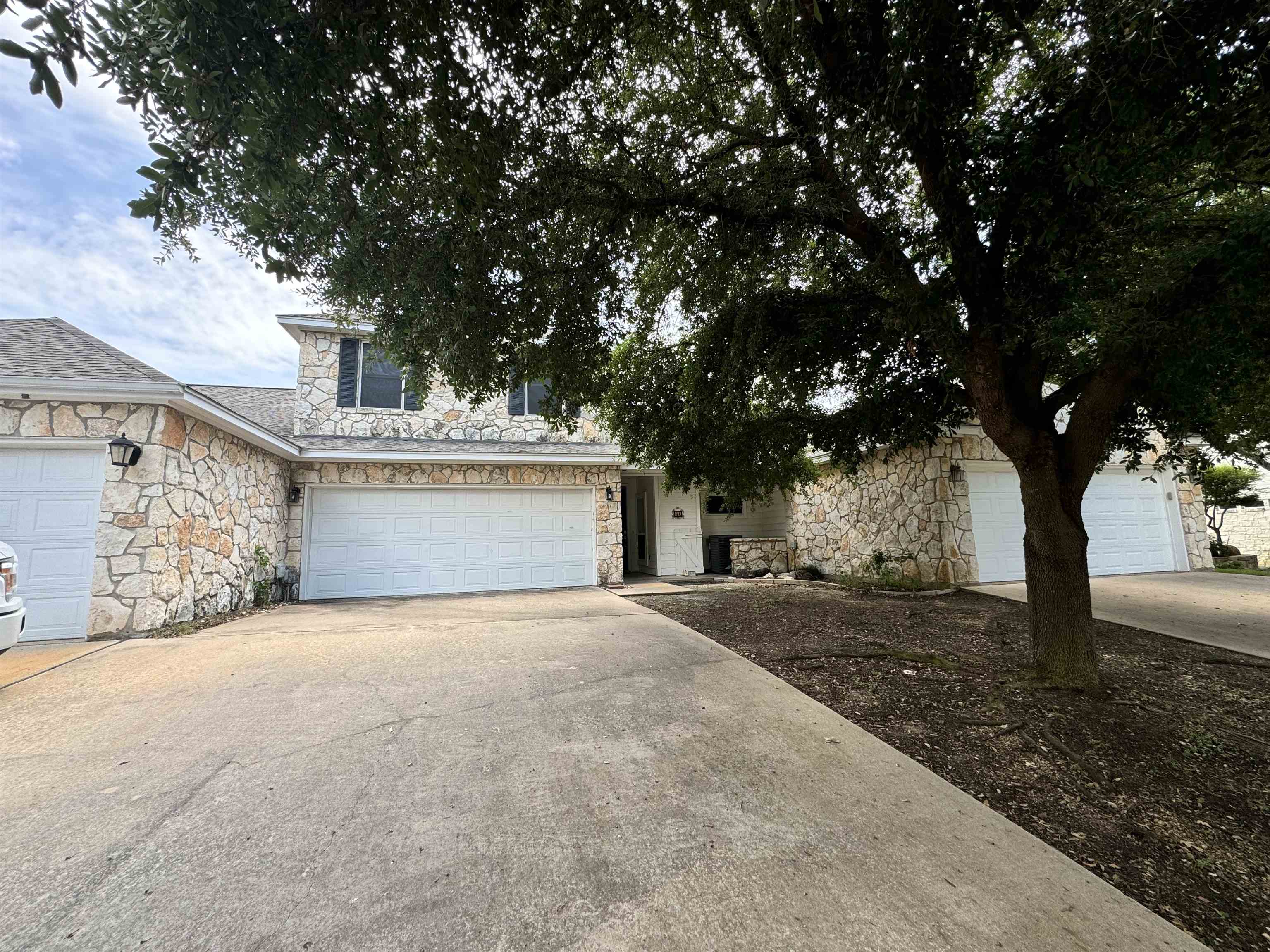 a view of a house with a tree in front of it