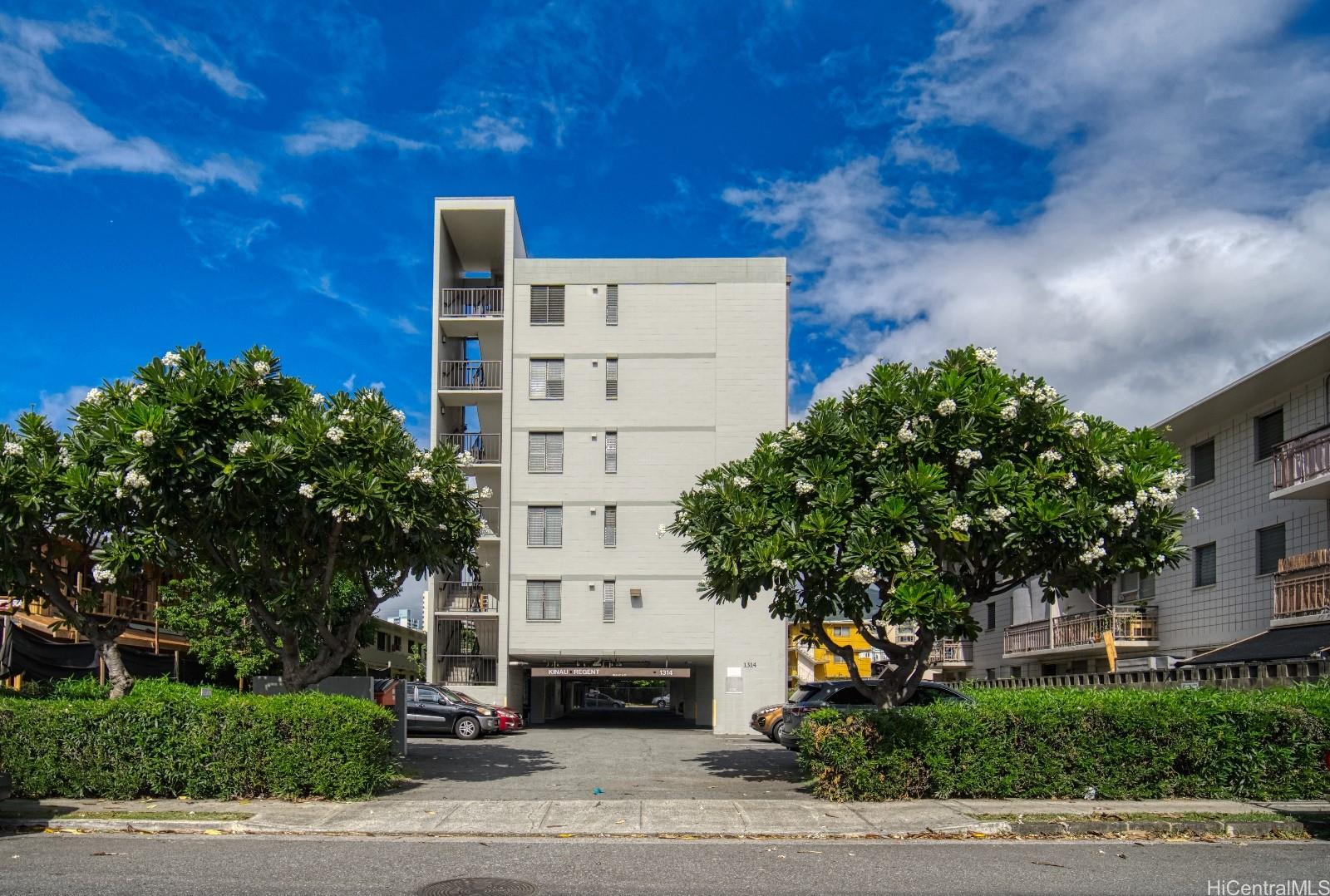 a front view of a building with trees