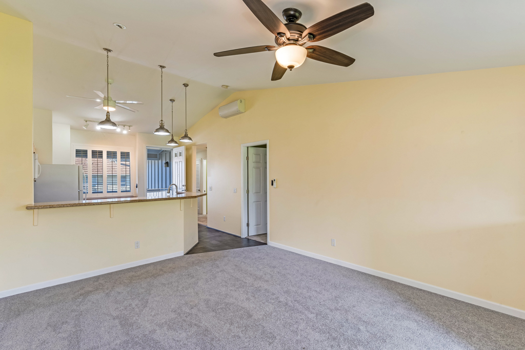 a view of a room with a kitchen and ceiling fan