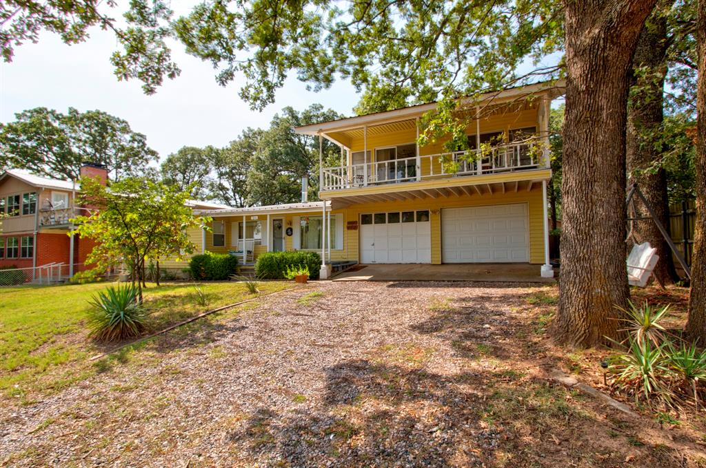 View of front of home featuring a front lawn, a garage, and a balcony