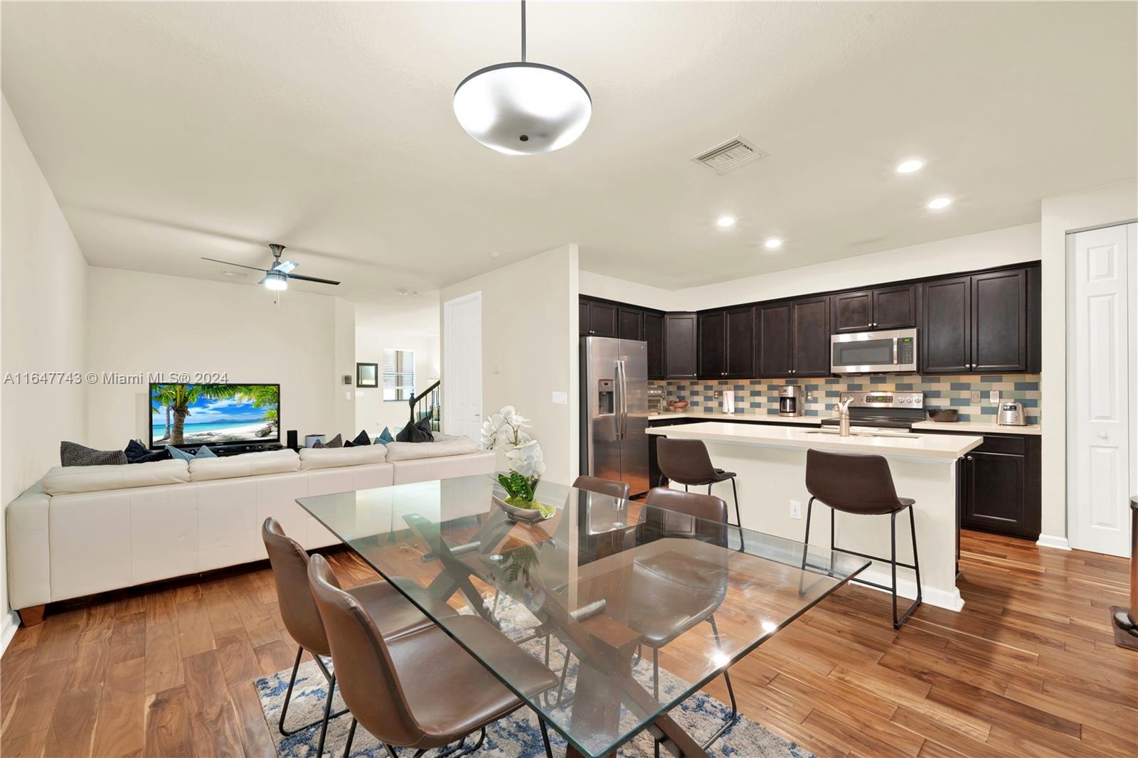 a kitchen with kitchen island a dining table and chairs