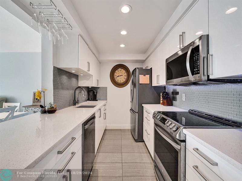 a kitchen with stainless steel appliances a sink a stove a microwave and cabinets