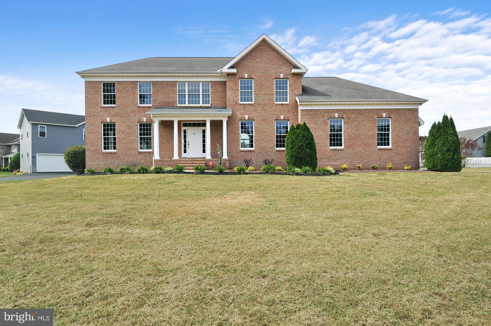 a front view of house with yard and green space