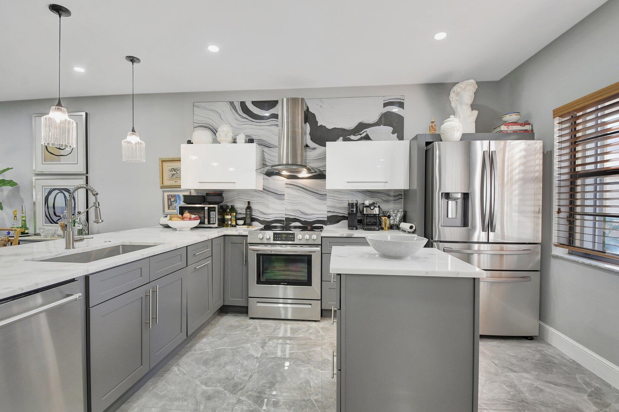 a kitchen with stainless steel appliances granite countertop a sink stove and refrigerator