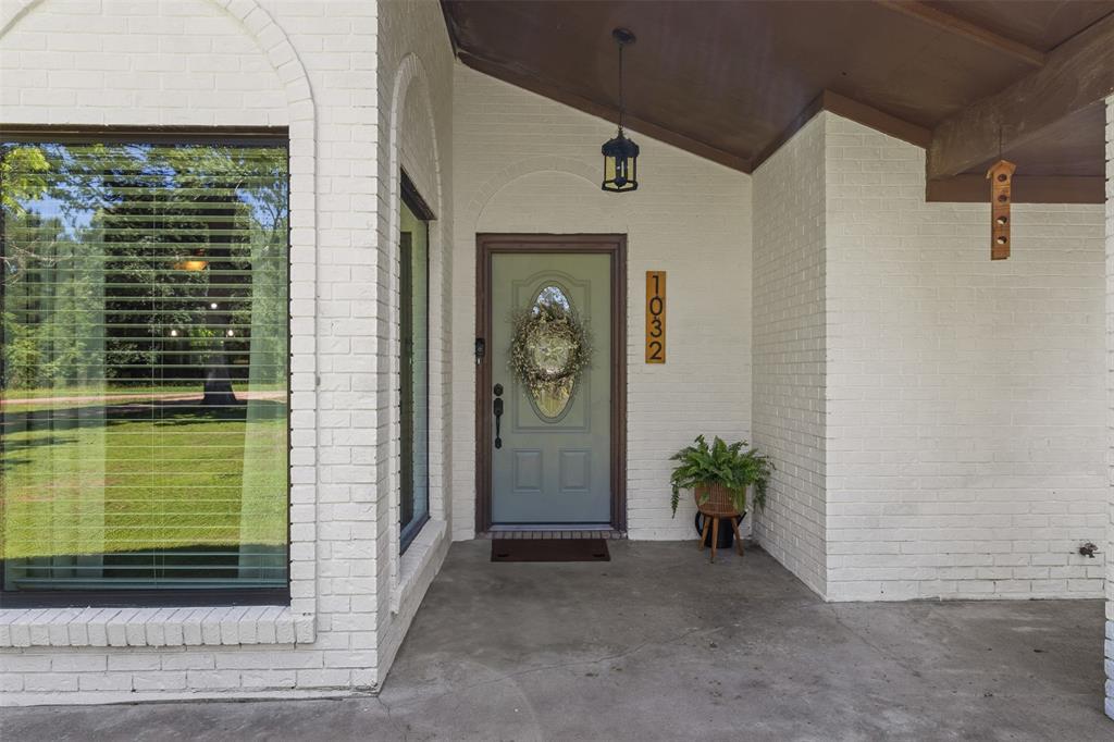 Discover the charm of 1032 Marek Road as you stroll up the inviting walkway, leading to a welcoming covered porch adorned with vibrant plants and a cheerful door, creating the perfect entry for your new home.